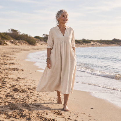 Lorne Elena Midi Dress in natural sand, walking along the shoreline